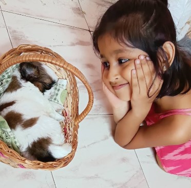 Baby Aazhiya posing with her pet dog